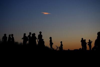 Silhouetten von Personen vor Abendhimmel