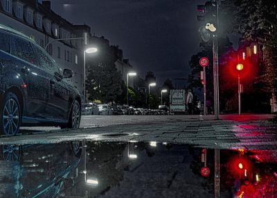 Nächtliche Straßenszene mit Pfütze