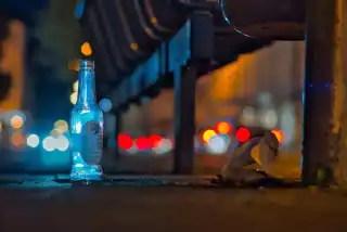 Nachtaufnahme einer leeren Flasche an der Bushaltestelle | Foto: Werner Pietschmann